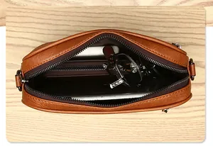 Interior view of brown leather crossbody bag showing spacious storage for phone and wallet