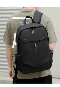 Détail du sac à dos noir étanche montrant le zip à rabat et la poche latérale à cordon