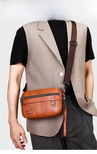 Close-up of vintage brown leather crossbody bag featuring adjustable fabric shoulder strap