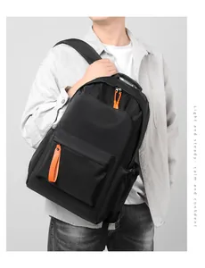 Detail of waterproof Oxford backpack with vibrant orange zipper pulls on black fabric