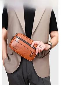 Close-up of brown litchi pattern leather clutch with metal zipper and wrist strap