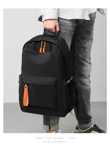 Detail of black waterproof backpack featuring contrast orange zippers for travel use