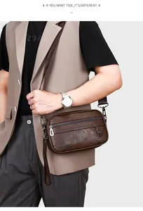 Detail of vintage brown leather shoulder bag featuring logo embossing and metal zippers