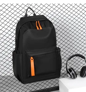 Detail of waterproof Oxford backpack showing vibrant orange zipper pulls on black canvas