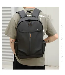 Détails du sac à dos noir montrant les accents orange et la poche latérale à cordon serré