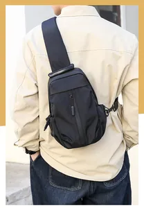 Rear view of model wearing a large black waterproof nylon crossbody chest bag