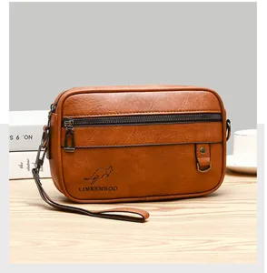 Brown leather crossbody bag with logo detail on a wooden table with a coffee cup