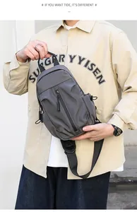 Close-up of waterproof dark gray crossbody bag showing multi-layer zipper pockets