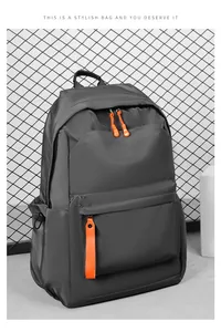 Detail of waterproof Oxford backpack showing large front pocket and vibrant orange zippers