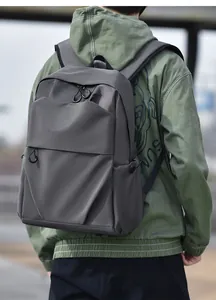 Outdoor shot of dark grey minimalist backpack with geometric cuts and side pocket details