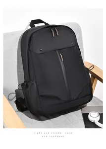 Détail du sac à dos d'affaires noir imperméable avec accents orange sur un fauteuil