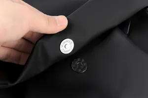 Gros plan d'une boucle magnétique en métal sur un sac à dos noir mat avec gravure