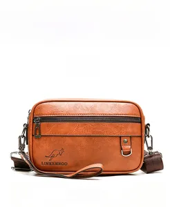 Detailed view of the khaki leather crossbody bag with lychee texture and brand logo
