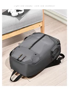 Détail d'un sac à dos gris foncé résistant à l'eau avec des accents de fermeture éclair orange