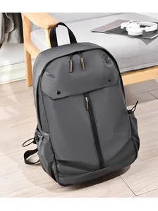 Détail d'un grand sac à dos de voyage gris avec tirettes orange sur parquet en bois