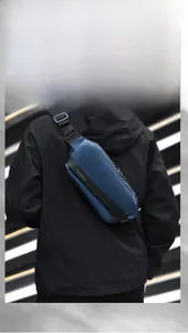 Detail of blue tactical chest bag featuring a metal zipper and branded nylon webbing strap