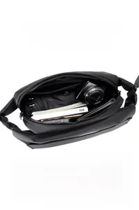 Detailed interior view of a black tactical crossbody bag showing large capacity storage