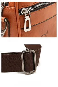 Detail of brown litchi grain leather bag with metal zipper and adjustable strap