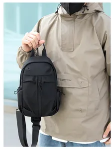 Dettaglio del borsello monospalla in nylon nero resistente con tasche multiple indossato