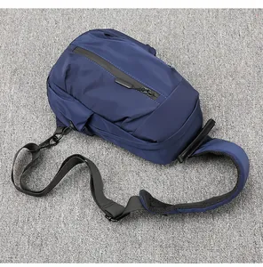 Detail view of water-resistant zipper and nylon fabric on deep blue men's sling bag