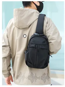 Borsa da petto nera resistente da uomo indossata durante attività all'aperto