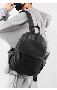 Side view of black waterproof laptop backpack with matte finish on a male model