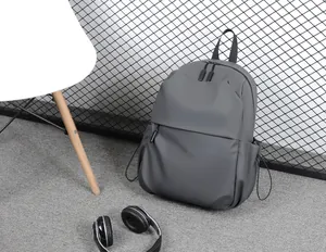 Détail du tissu imperméable du sac à dos gris foncé avec poche latérale à cordon serré