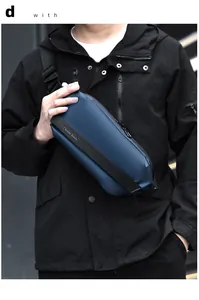 Detail shot of the matte navy blue crossbody bag worn by a model in a dark setting