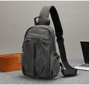 Dettaglio borsa a tracolla in nylon grigio scuro con tessuto impermeabile e zip frontale