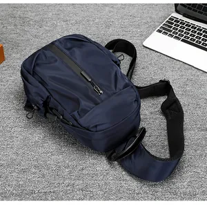 Dettaglio borsa a tracolla blu navy impermeabile con tracolla in rete su una scrivania