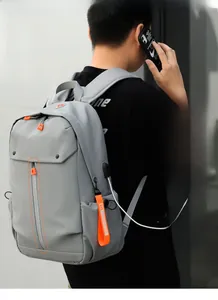Détail du sac à dos gris avec fermeture éclair réfléchissante et port de charge USB