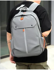 Détail d'un sac à dos gris avec fermetures orange et bretelles rembourrées
