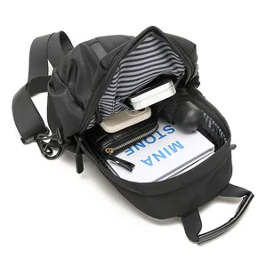 Black waterproof chest bag with large capacity showing books and items inside main pocket