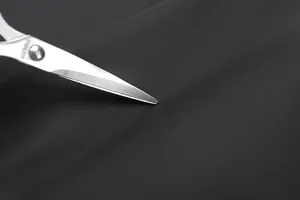 Détail du tissu noir mat résistant aux rayures avec un test de durabilité à l'outil métal
