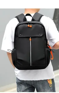 Détail du sac à dos noir montrant la texture en nylon et les accents orange