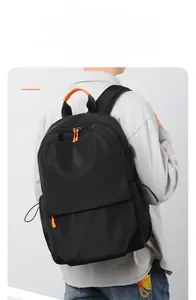 Detail of laptop backpack showing external USB charging port and orange zipper accents