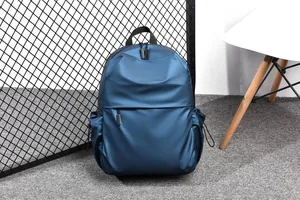 Détail d'un sac à dos bleu marine imperméable avec poche frontale et porte-bouteille latéral