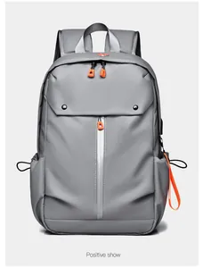 Vue avant d'un sac à dos gris pour ordinateur avec fermetures éclair orange vif