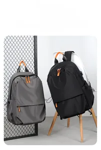 Close-up of waterproof nylon backpack showing integrated external USB charging port and cable