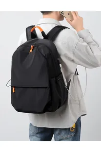 Detail showing side USB charging port on a black waterproof laptop backpack with phone
