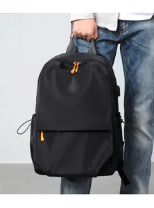 Detail of black waterproof backpack with vibrant orange accents and side drawstring pocket