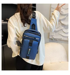 Détail montrant la vue arrière du sac bandoulière bleu sur un modèle dans un décor moderne
