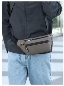 Gros plan d'un sac banane de sport gris étanche porté par un mannequin en extérieur