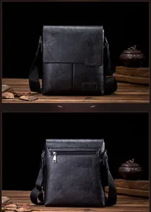 Detailed back view of vintage black leather messenger bag with zip pocket on wooden table