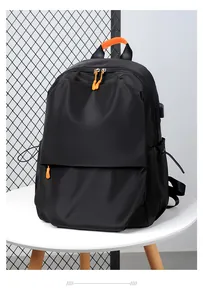 Detailed view of black travel backpack with orange accents and external USB port