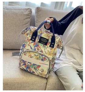 Detailed side view of large unicorn print diaper backpack on a sofa showing side pocket