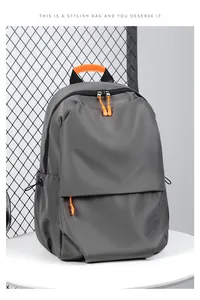 Detail of grey backpack showing bright orange handle and side drawstring pocket