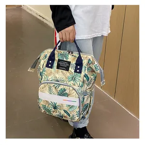 Detail of waterproof diaper bag featuring a tropical leaf pattern and top handle