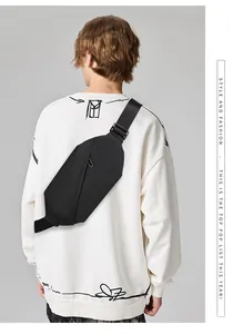 Rear view of a minimalist black oxford crossbody bag worn over a white hoodie