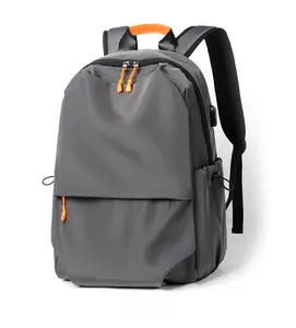 Detail view of grey travel backpack with side USB charging port and orange zipper accents